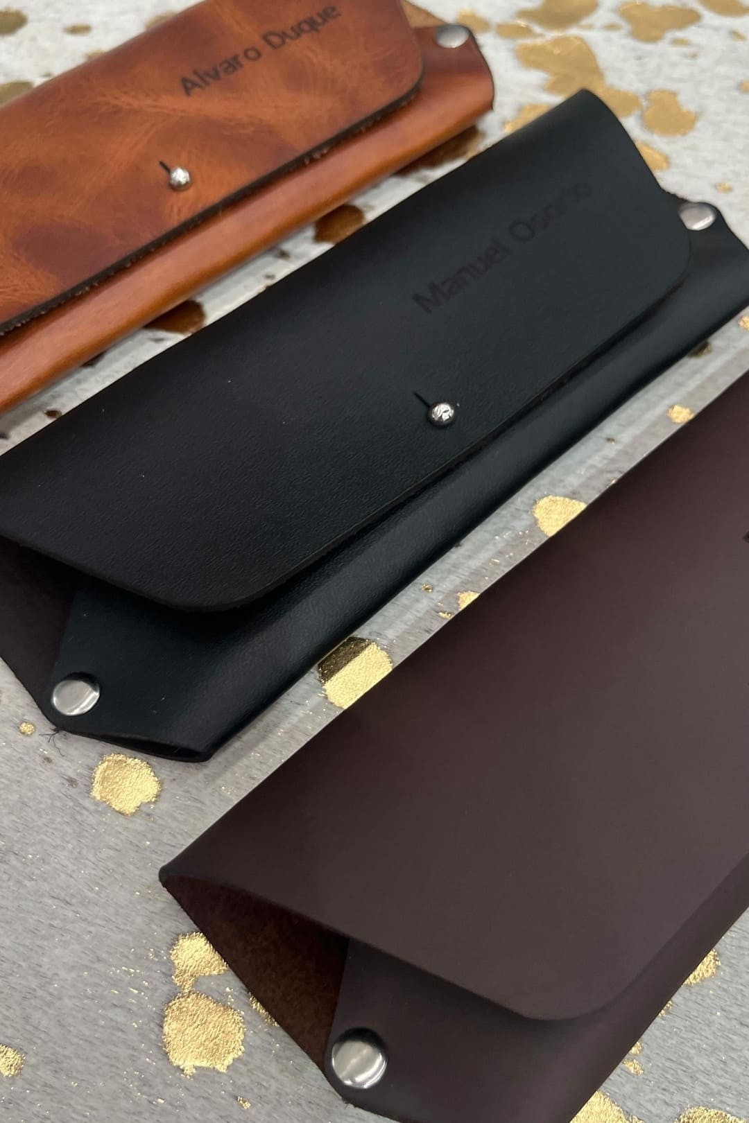 Estuches para gafas en cuero rústico miel, negro y café; el miel y el negro con nombres grabados