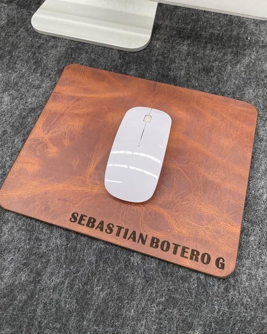 Mouse pad de cuero miel con un nombre grabado y un mouse encima