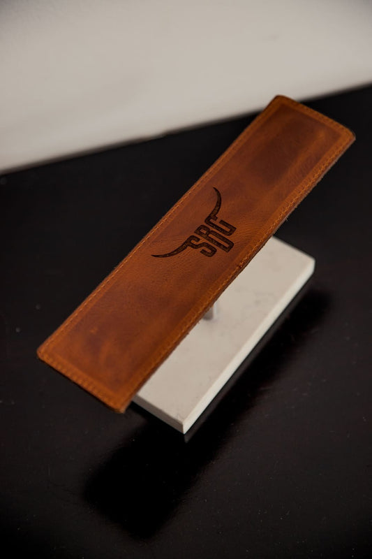 Soporte para relojes en cuero rústico miel vacío, con un logo grabado en la pieza de cuero